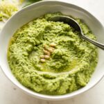 Small white bowl full of zucchini pesto.