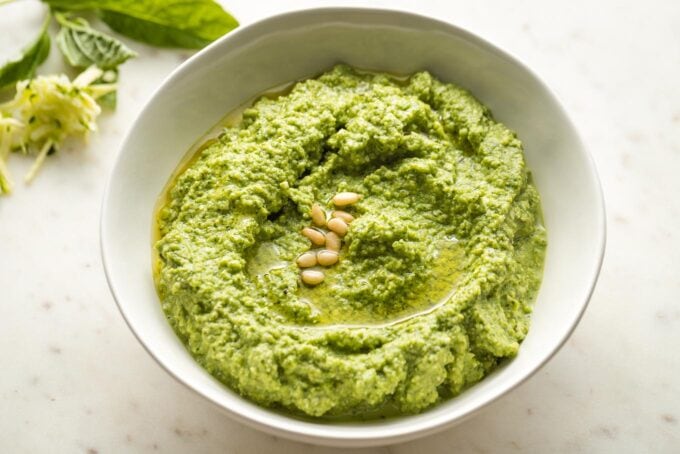 Small white bowl full of zucchini pesto.