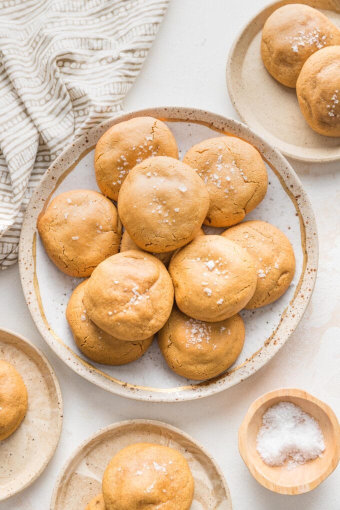 Small plate filled with caramel molasses cookies sprinkled with sea salt.