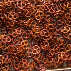Sheet pan full of homemade honey mustard pretzels, with extra honey on the counter nearby.