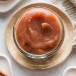 Small jar full of homemade Instant Pot apple butter resting on a counter.