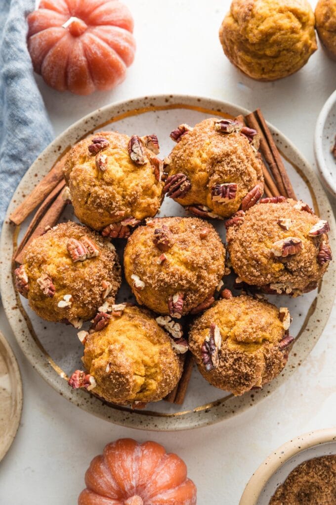 Small plate filled with pumpkin muffins topped with a brown sugar cinnamon pecan crunch topping.