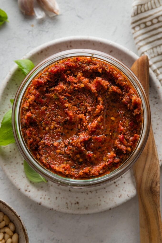 Close up of homemade sun-dried tomato pesto (pesto rosso) in a glass jar.