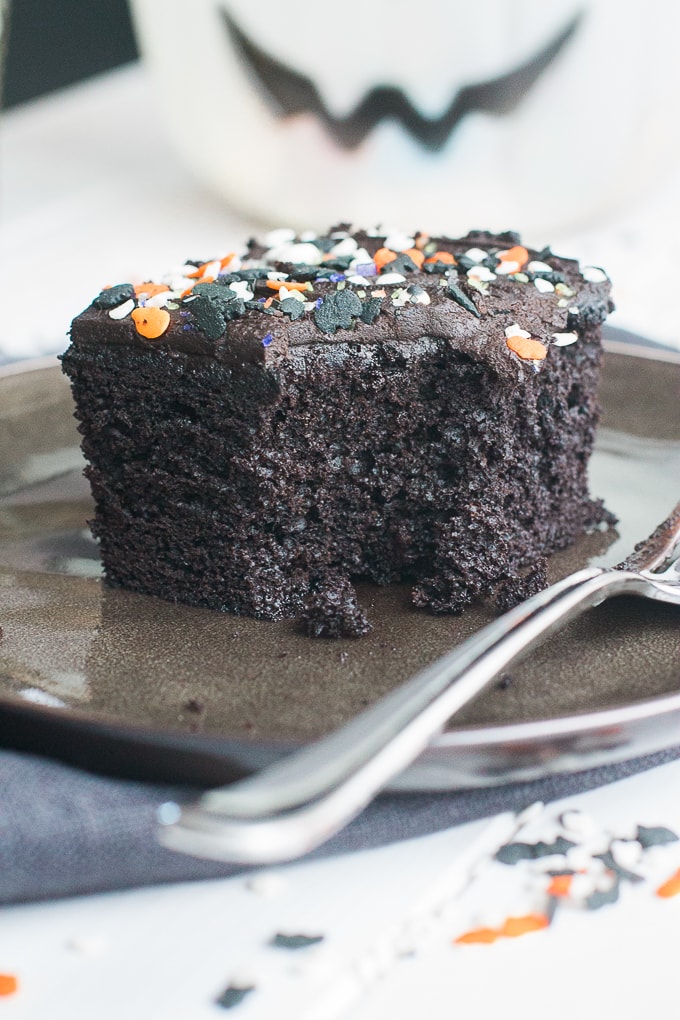 A slice of spooky blackout chocolate buttermilk cake with one forkful removed.