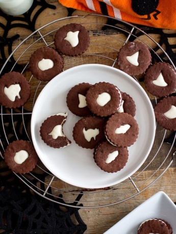 Spooky chocolate Linzer cookies | Dark chocolate sugar cookies sandwiched with an easy marshmallow cream frosting, with spooky cut-outs for a Halloween treat! #halloween #chocolatesugarcookies