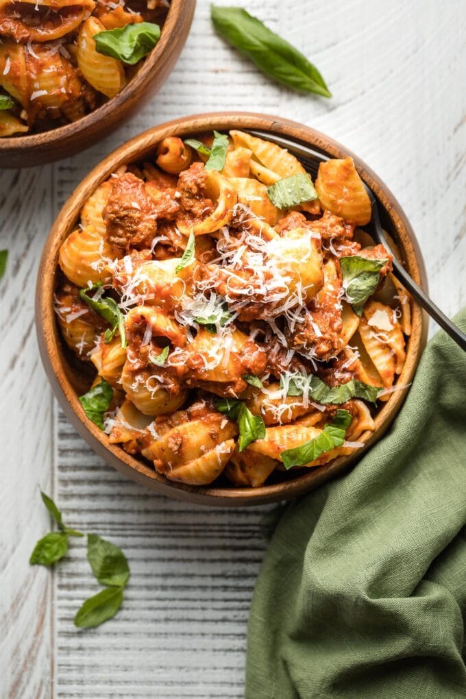 Close-up of a wooden bowl holding a serving of weeknight bolognese with shells.