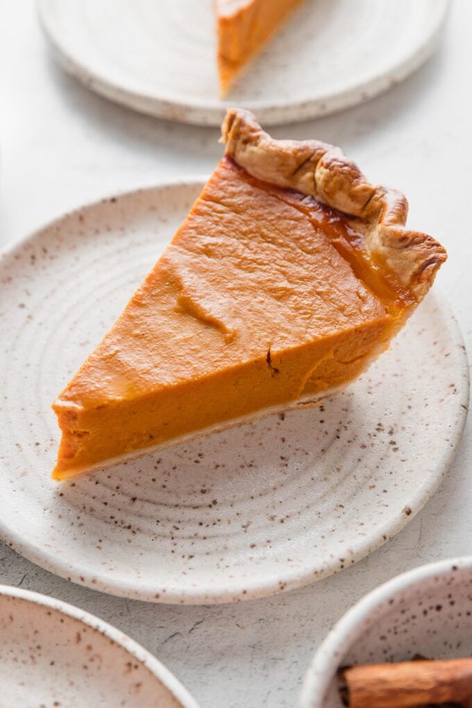 Angled view of a perfect slice of pumpkin pie.