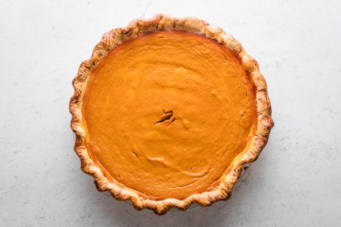 Just-baked pumpkin pie, resting on a countertop.