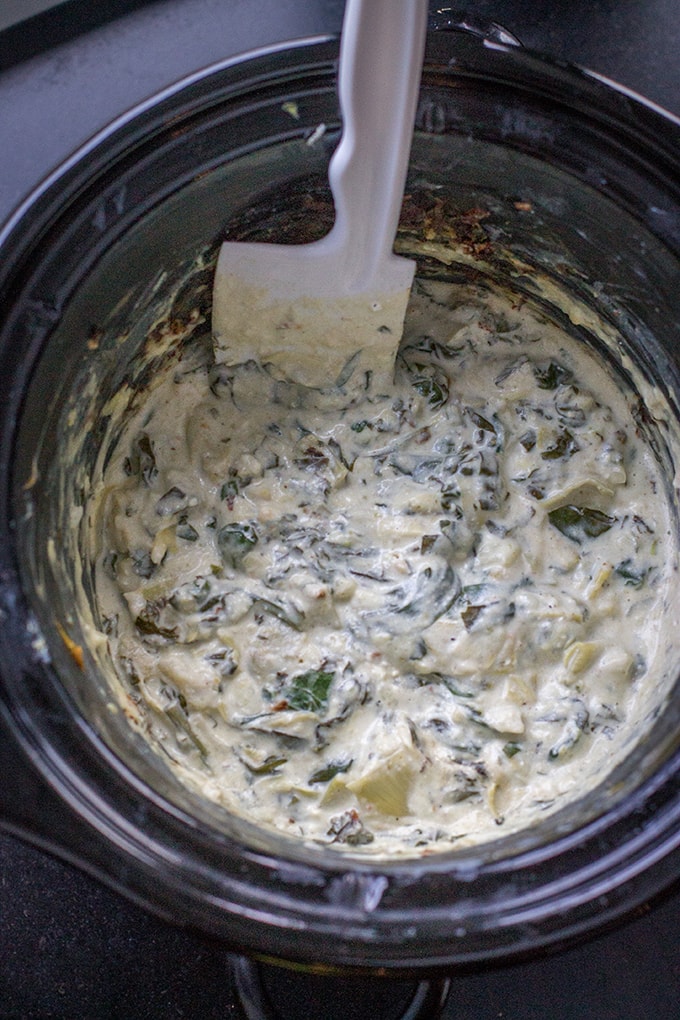 Skinny crockpot spinach artichoke dip, cooked in the crockpot and ready to serve.