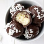 A close-up image of dark chocolate coconut truffles.
