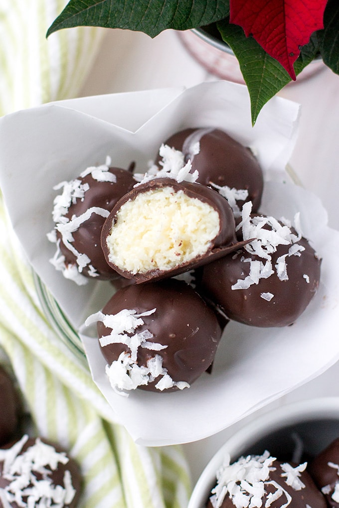 Close-up image of dark chocolate coconut truffles, with one lying on top with a bite out of half.