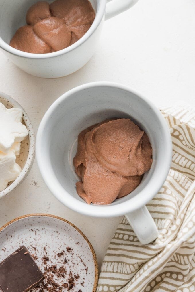A large scoop of hot cocoa cream base at the bottom of a mug.
