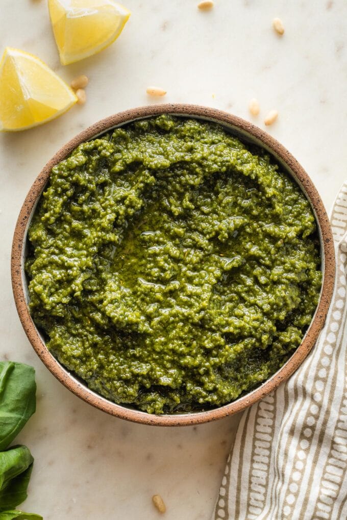 Small bowl filled with basil pesto with lemon.