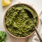 Small bowl filled with basil pesto with lemon.