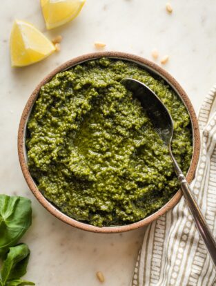 Small bowl filled with basil pesto with lemon.