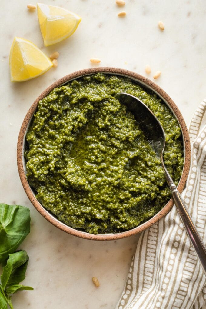 Small bowl filled with basil pesto with lemon.