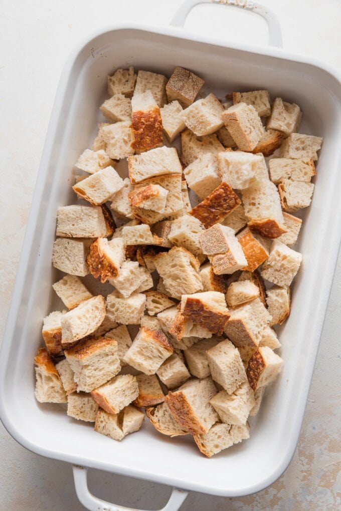 Bread cubes spread in a large baking pan.