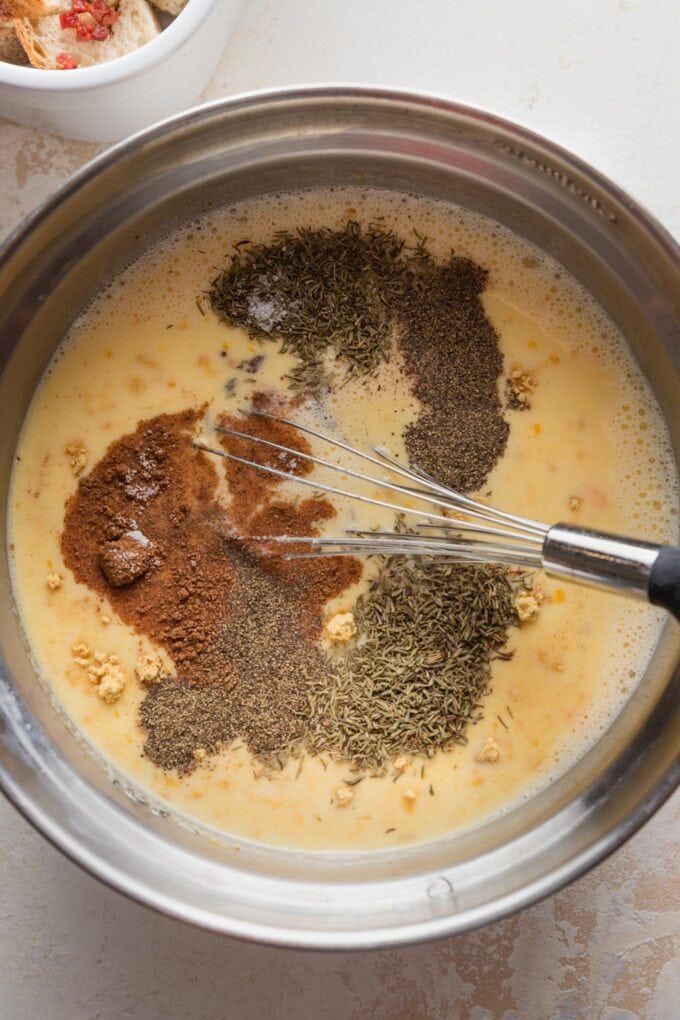 A dozen eggs whisked together with milk, dried mustard, nutmeg, thyme, black pepper, and salt.