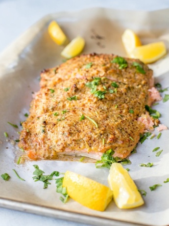 A large piece of salmon baked and coated with a crunchy mustard-panko crust, sliced into 3 sections.