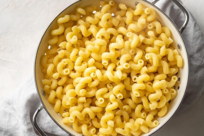 Cooked cavatappi noodles in a colander.