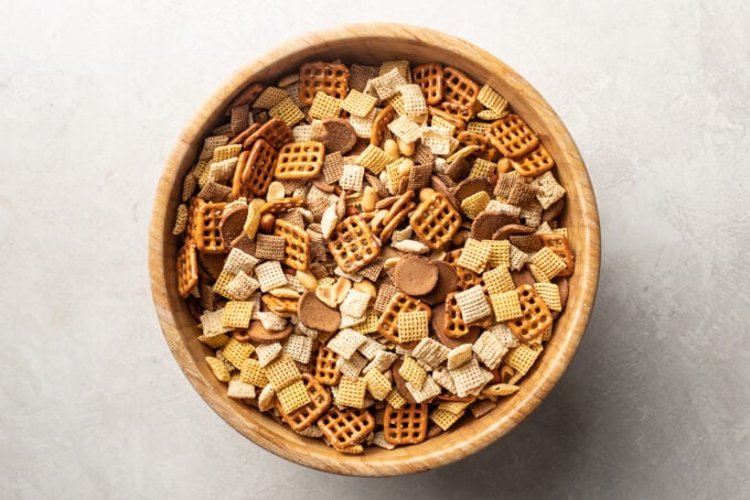 Wooden mixing bowl full of Chex mix.