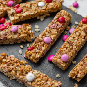 A slate tray filled with M&M pretzel granola bars.