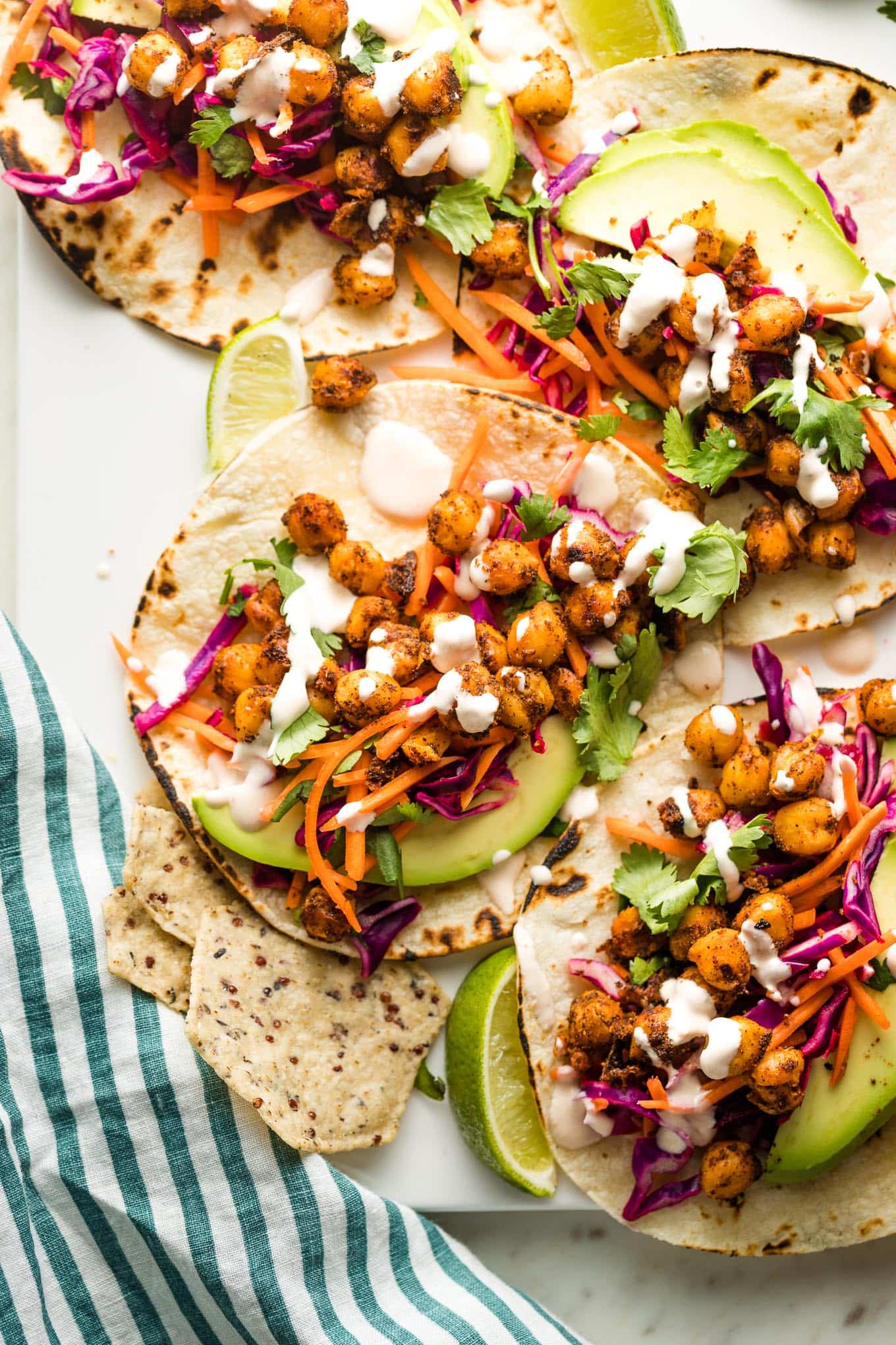 Crispy chickpea tacos with sunset slaw and a creamy sauce arranged on a serving tray.