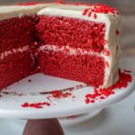 A cut open cross-section of red velvet layer cake.