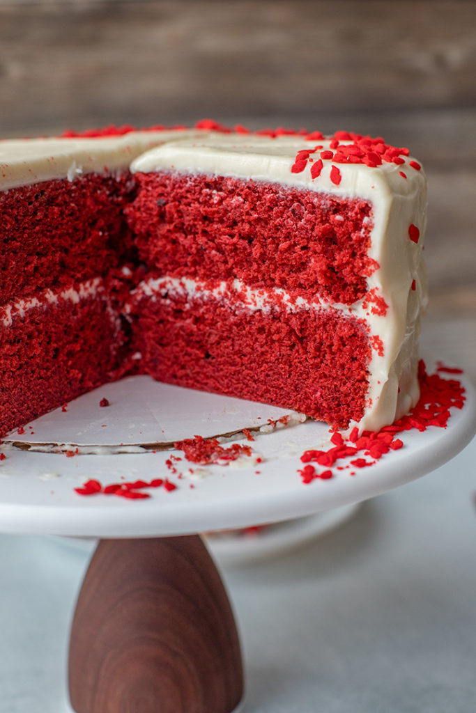 A cut open cross-section of red velvet layer cake.