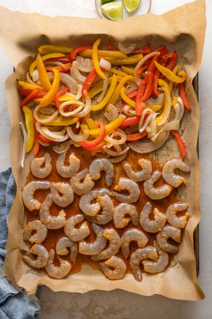 Shrimp marinated in a chipotle lime blend and added to a sheet pan with peppers and onions.