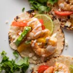 Close up of a sheet pan shrimp fajita with pepper, onion, and chipotle lime crema.