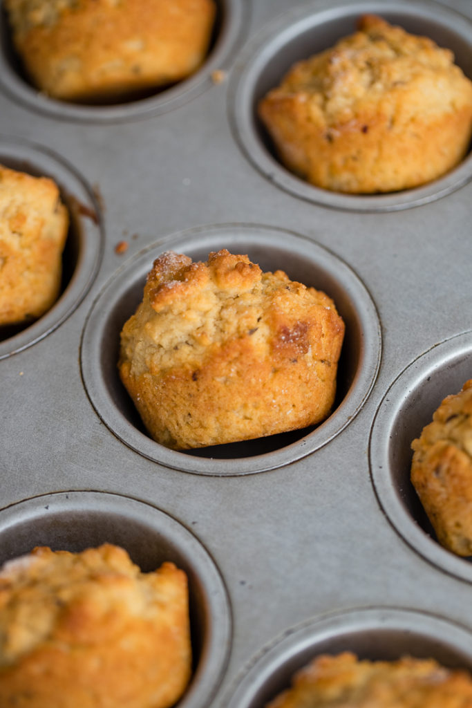 Irish soda bread muffins tilted in the pan after baking to prevent soggy bottoms.
