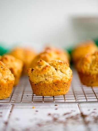 Caraway Irish soda bread muffins arrayed on a cooling rack, with just one in focus.