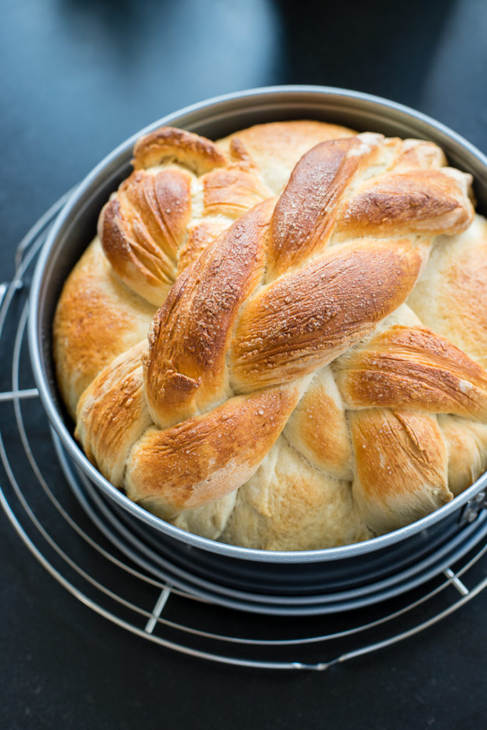 A just-baked loaf of homemade paska, the traditional Slovak Easter bread, still in the pan and resting on a cooling rack.