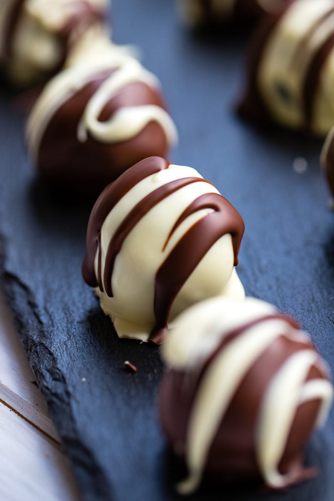 Close-up of a white chocolate-coated Irish cream Oreo truffle.