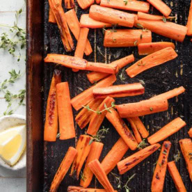 Small sheet pan with roasted whole carrots with butter, salt, pepper, and thyme.