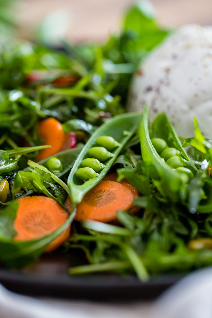 Close-up of an open sugar snap pea in a spring salad.