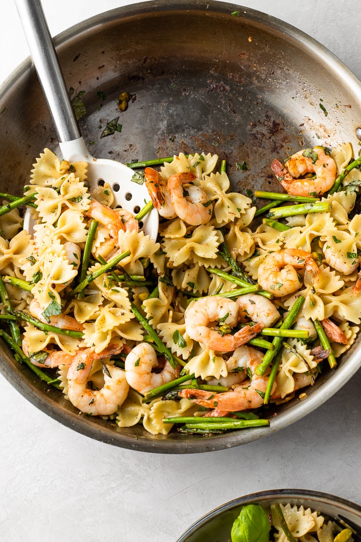 Skillet filled with lemon asparagus shrimp pasta.