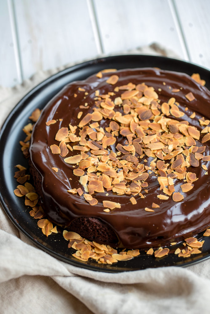 Gluten-free chocolate cake topped with chocolate ganache and toasted slivered almonds.