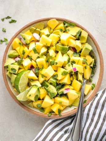 Close up of mango avocado salsa in a bowl with a spoon.