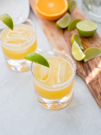 Two cocktail glasses filled with skinny margaritas and garnished with fresh lime.