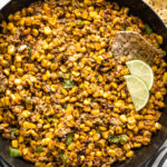 Skillet full of skinny chipotle street corn dip, served hot with tortilla chips.