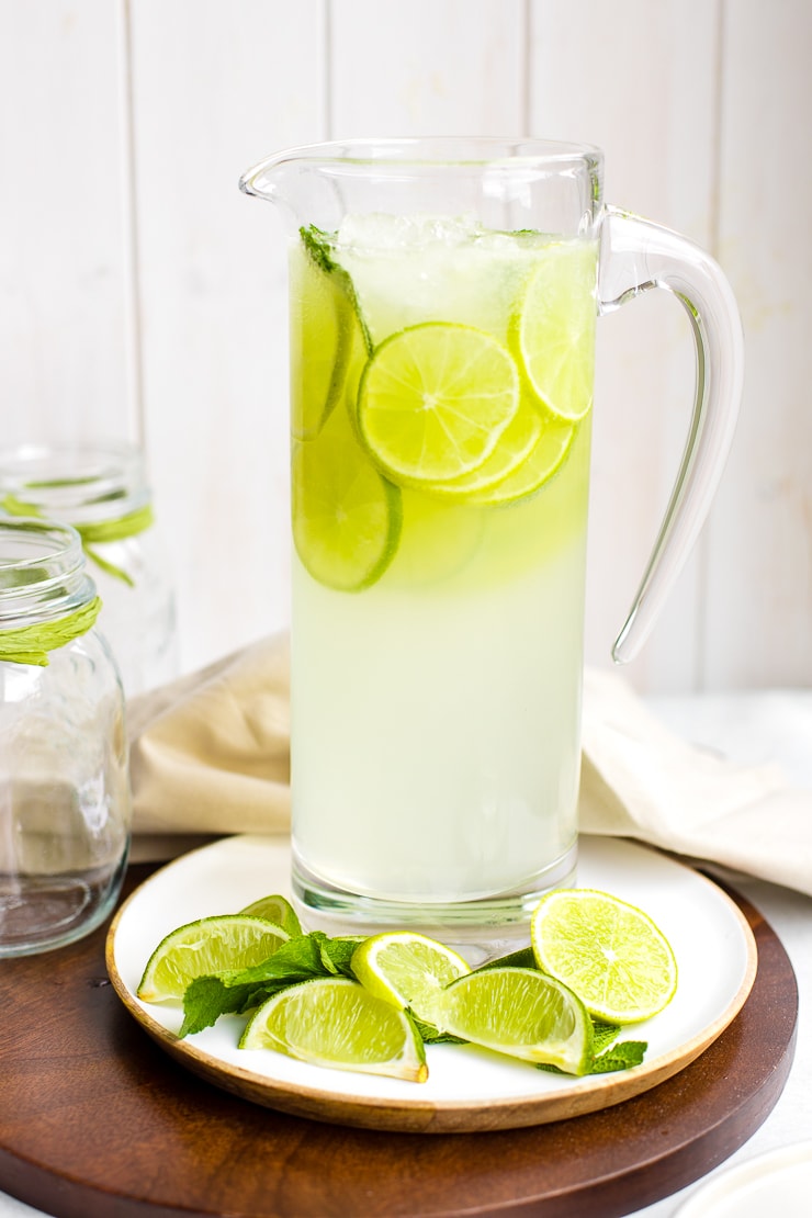 A tall glass pitcher filled with sparkling limeade.