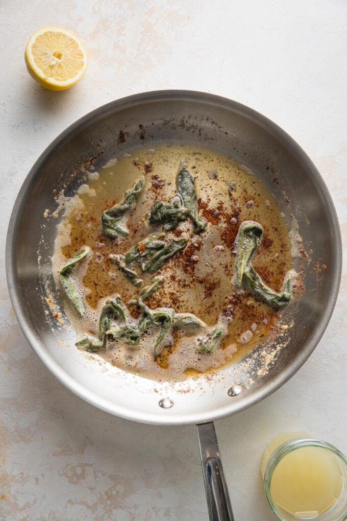 Crisped sage leaves in a skillet with browned butter.