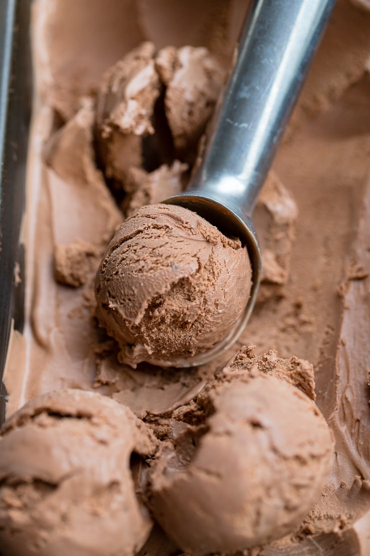 Close up of a metal ice cream scoop serving double chocolate ice cream.