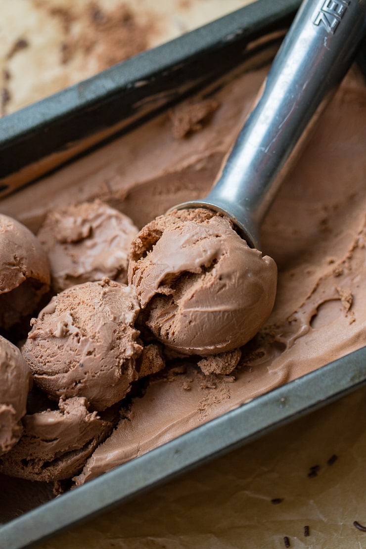 Close up of a metal ice cream scoop serving double chocolate ice cream.