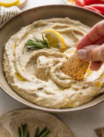 This garlic rosemary white bean dip is simple, healthy, and delicious. It's a terrific addition to any party platter or appetizer spread, but equally deserving as a simple snack to enjoy yourself. We love it with pita, tortilla wedges, or crisp raw veggies.