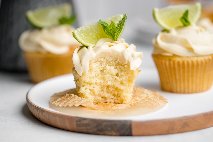 Mojito cupcake on a white plate with one bite removed.