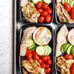 Chicken hummus bistro boxes packed with cucumber, cherry tomatoes, and a mini pita.