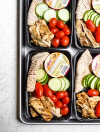 Chicken hummus bistro boxes packed with cucumber, cherry tomatoes, and a mini pita.